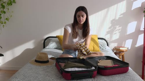 Young Woman Packing Suitcase for a Vacation