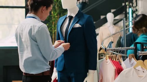 Trabajador arreglando maniquí con traje