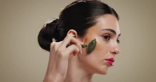 Woman, jade roller and beauty in studio with skincare for circulation, anti aging