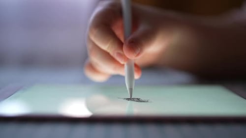 Hand Using Stylus Drawing on Tablet Close-up