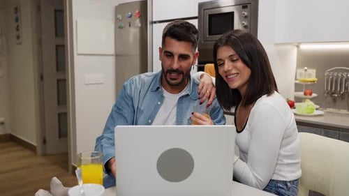 Couple Using Laptop in Modern Kitchen at Home