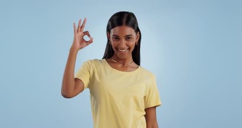 Okay sign, face and woman in studio for vote, certified review or feedback on blue background