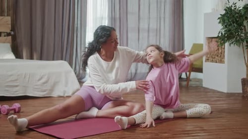 Adult and Child Stretching on a Yoga Mat