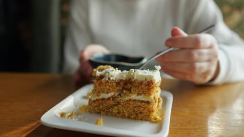 Woman Eating Carrot Cake in Cafe