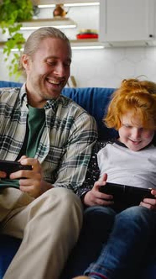 Father and son playing video games at home