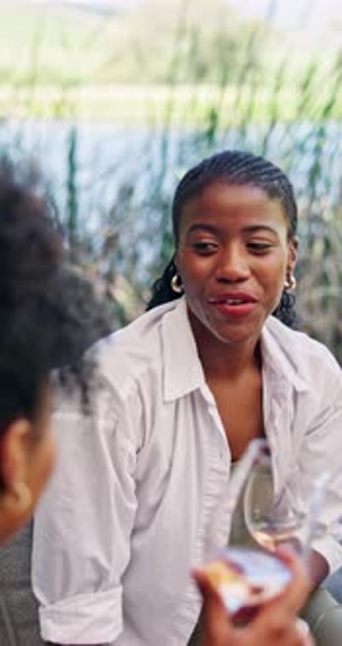 Two Women Chatting and Toasting with Rose Wine Outdoors