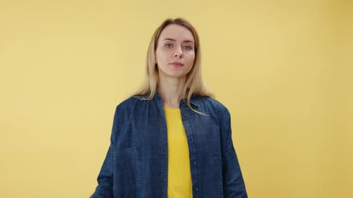 Woman Gesturing No with Hand Signals on Yellow