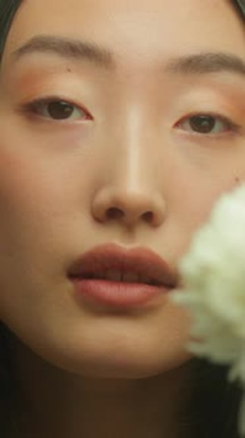 Close-Up of Young Woman with White Flower