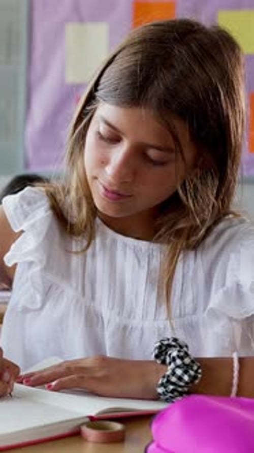 Young Student Teen Girl Writing in Notebook While Studying at Elementary School