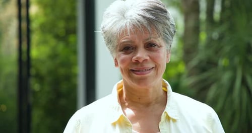 Smiling Senior Woman Close-up in Tropical Garden