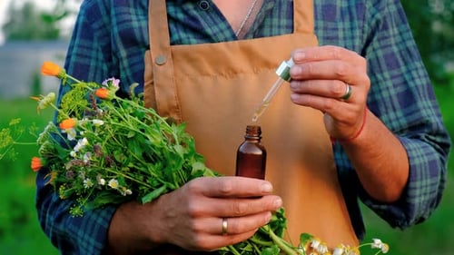 Man with Medicinal Herbal Extracts in His Hands Selective Focus