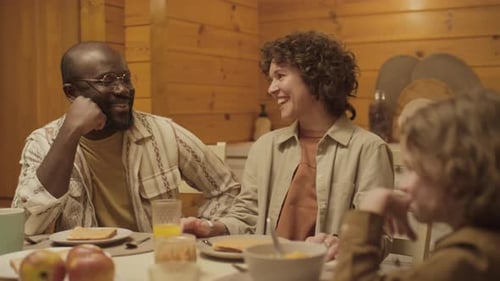 Family Laughing and Communicating During Meal at Home