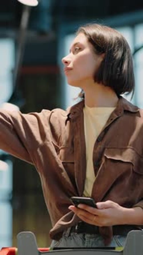Woman Holding Phone and Grocery Shopping Indoors