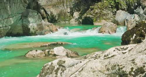 Um poderoso fluxo de água turquesa se move muito rápido sobre as rochas. Fluxo violento de um rio de montanha de águas brancas