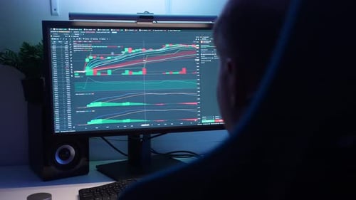 Back View of Unrecognizable Male Trader Analyzing Realtime Stocks Exchange Market Charts on Desktop