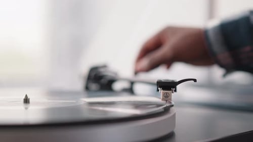 Man Puts Phono Stylus on Vinyl Disk in Turntable