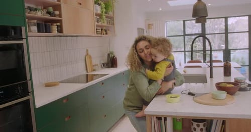 Mother Holding Child in Modern Kitchen