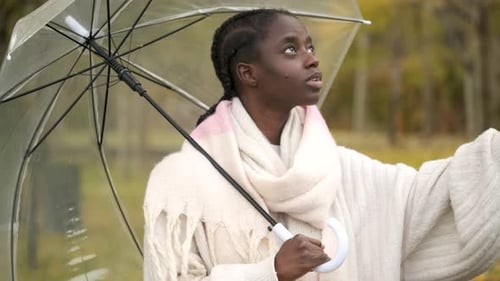 Woman with Braids Holding Umbrella in Autumn Park