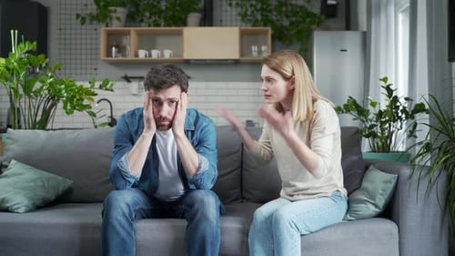 Couple Arguing on Sofa in Home Living Room