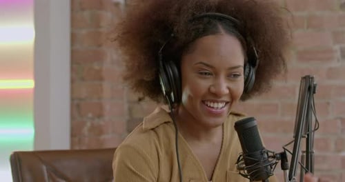 One Young adult Podcast Presenter in Studio Talking into Microphone
