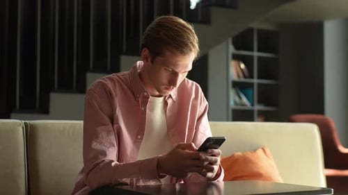 Young Man Using Mobile Phone Indoors