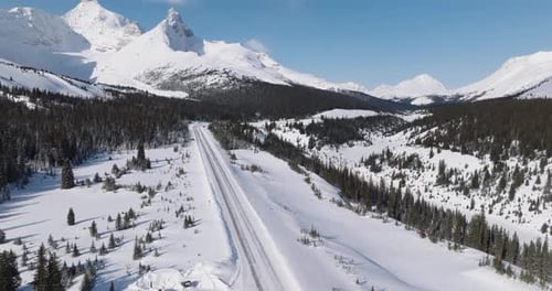 aerial view of highway between mountains in canadian rocky mountains touching the clouds