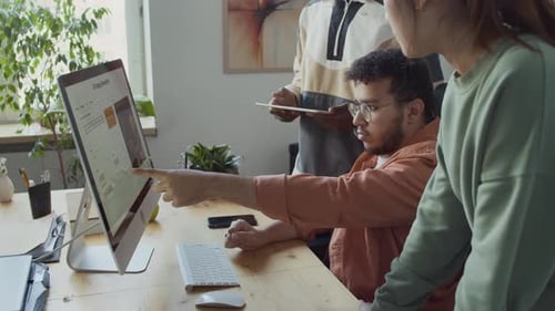 Junger Entwickler schlägt verschiedenen Kollegen eine Lösung für einen Bug-in-Code vor