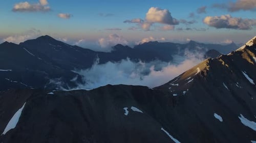 Enticing Snowy Mountains Shrouded in Cloudy Sky Pristine Nature Drone View Enticing Snowy Mountains