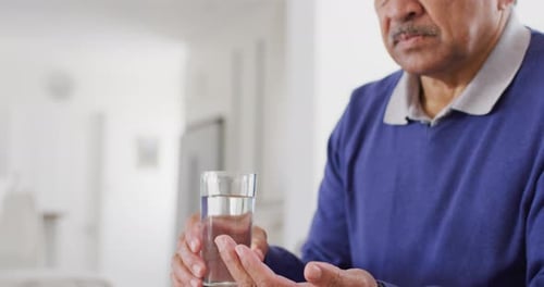 Senior Man Taking Medication With Water