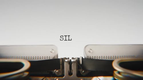 Old mechanical typewriter typing Silence in a close-up view.