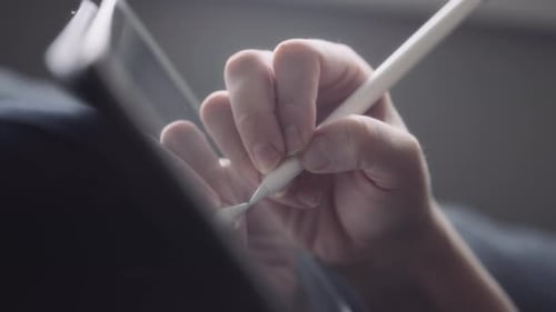 Close-Up of Hand Using Stylus on Tablet