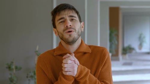 Man Speaking Sincerely with Clasping Hands Indoors