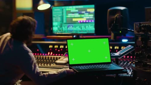 Técnico de Audio nivelando el sonido en la consola de mezclas de la grabadora