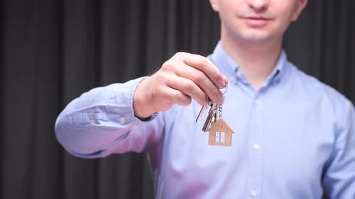 Real Estate Agent Holding House Keys with Keychain in Shape of House