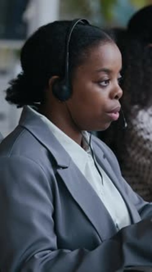 Operator in Headset Consulting Online Client and Typing against Colleague