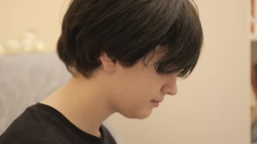 Teen Puts in Earplugs for Hearing Protection Indoors