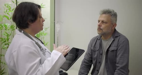 Female Doctor Explains Test Results to Mature Male Patient
