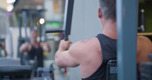Gym Workout Butterfly Exercise Back View of a Middle Aged Caucasian Man Trains Chest in the Gym
