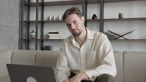 Businessman Looking At Camera And Smiling While Sitting In Stylish Home Office
