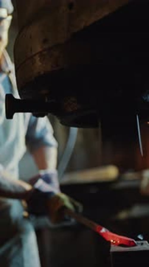 Worker Shapes Red Hot Metal with Metal Press