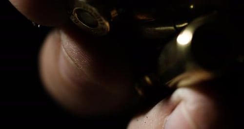 Detailnahaufnahme von Finger, die glänzende Kugeln halten und dann fallen lassen