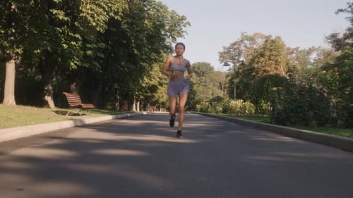 Fit Woman Runs Through Park