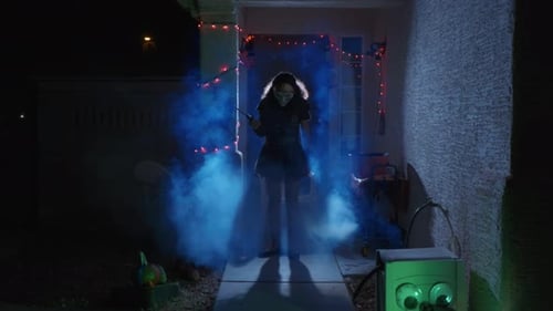 A Girl in scary Halloween costume holds a as the camera slowly approaches her, she raises her head