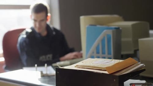 Police Officer Working at Desk in Office