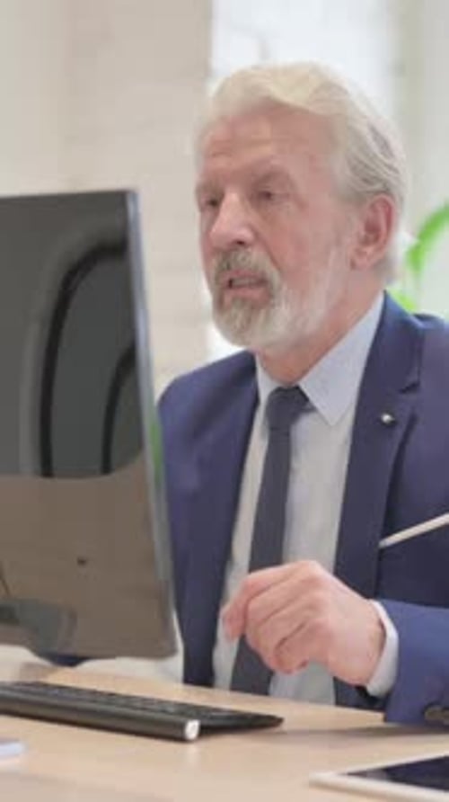 Senior Man Attending Video Call at Desk