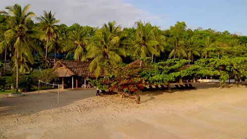 Aerial pan across sunny beach in Lombok, Indonesia.