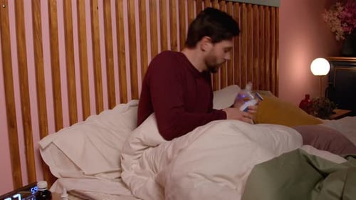 Un homme d'âge moyen malade et choqué traite une crise d'asthme avec un inhalateur au lit