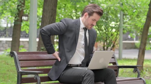 Man Using Laptop Suffers from Back Pain