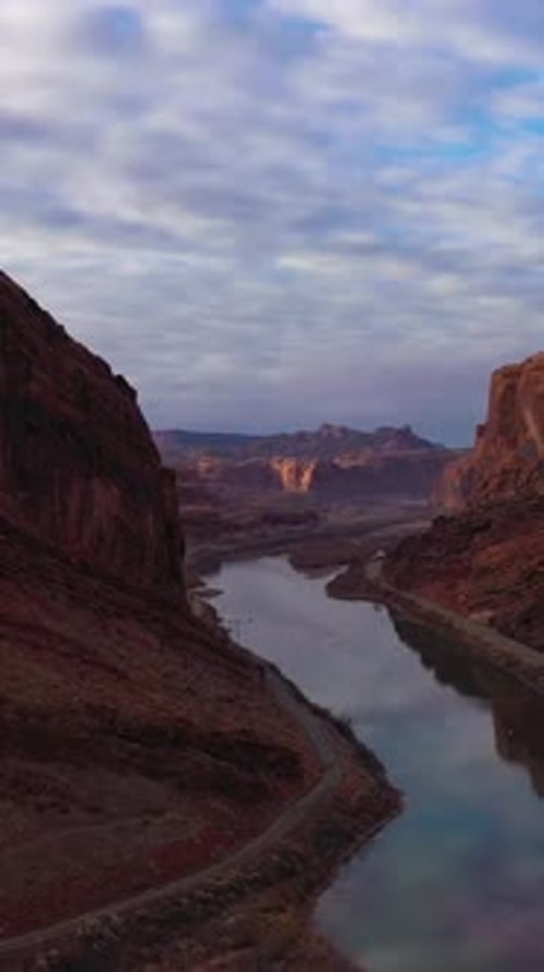 Colorado River and Red Sandstone Mountains on Cloudy Morning Utah USA Aerial View Vertical Video