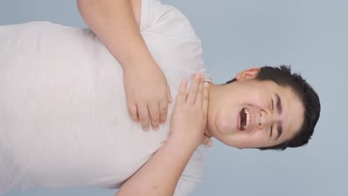 Young Adult Massaging Sore Throat in Studio